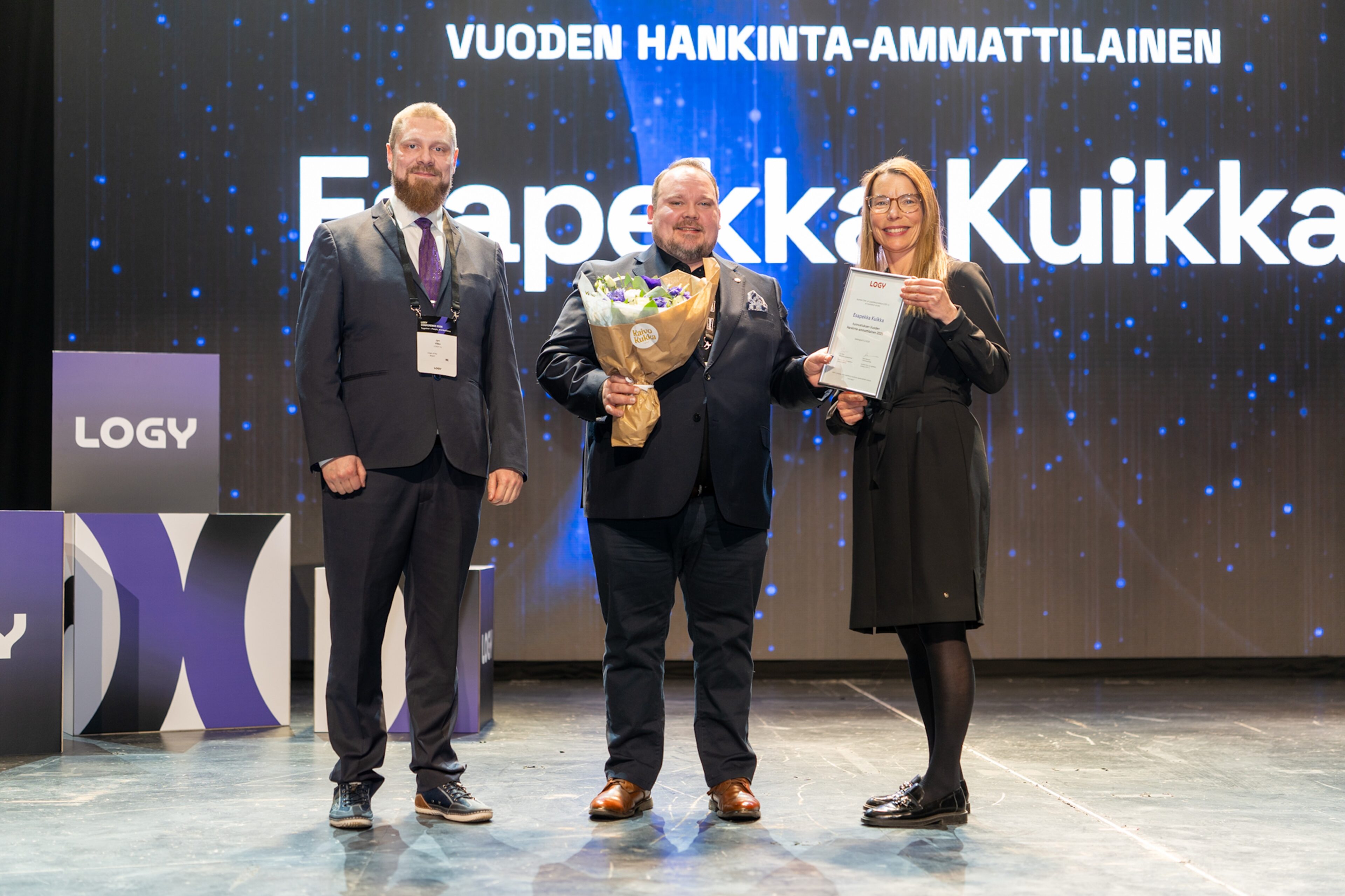 LOGY Conferencessa palkinnon Esapekka Kuikalle (keskellä) ojensivat LOGY:n hallituksen puheenjohtaja Jyri Vilko ja palkintovaliokunnan puheenjohtaja Anna Aminoff. Kuva: Sami Siilin